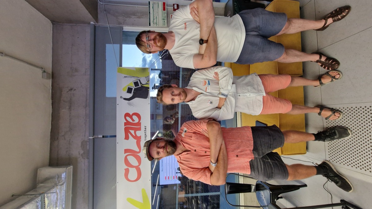 CoLab team under the building together banner in Lisbon